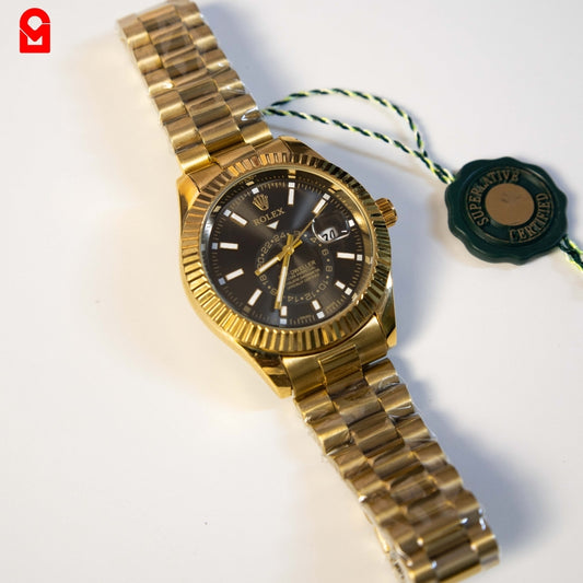 Gold tone automatic watch with black dial and fluted bezel on white background.
