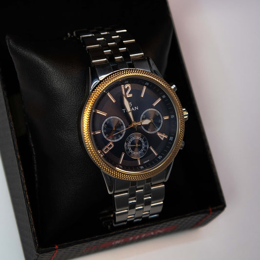 Close-up of men’s analog chronograph watch with black dial and stainless steel bracelet.