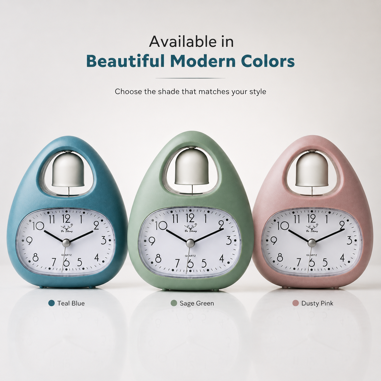 Single bell analog alarm clock available in teal blue, sage green, and dusty pink colors with quartz movement and modern tabletop design.