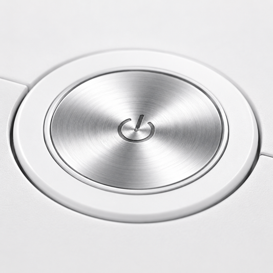 Close-up of the robot vacuum cleaner's premium metallic power button on a white body, featuring a brushed aluminum finish and minimalist one-touch control design.