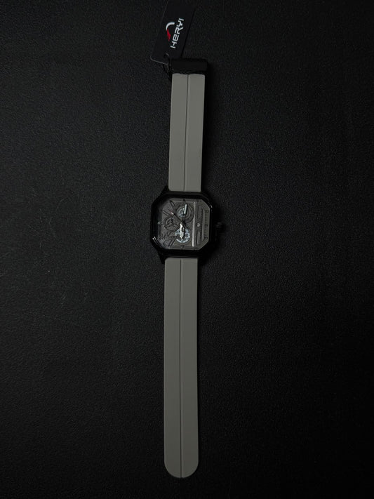 Grey silicone strap replica watch with black square case and detailed multi-layer skeleton style dial, luxury-inspired fashion timepiece.