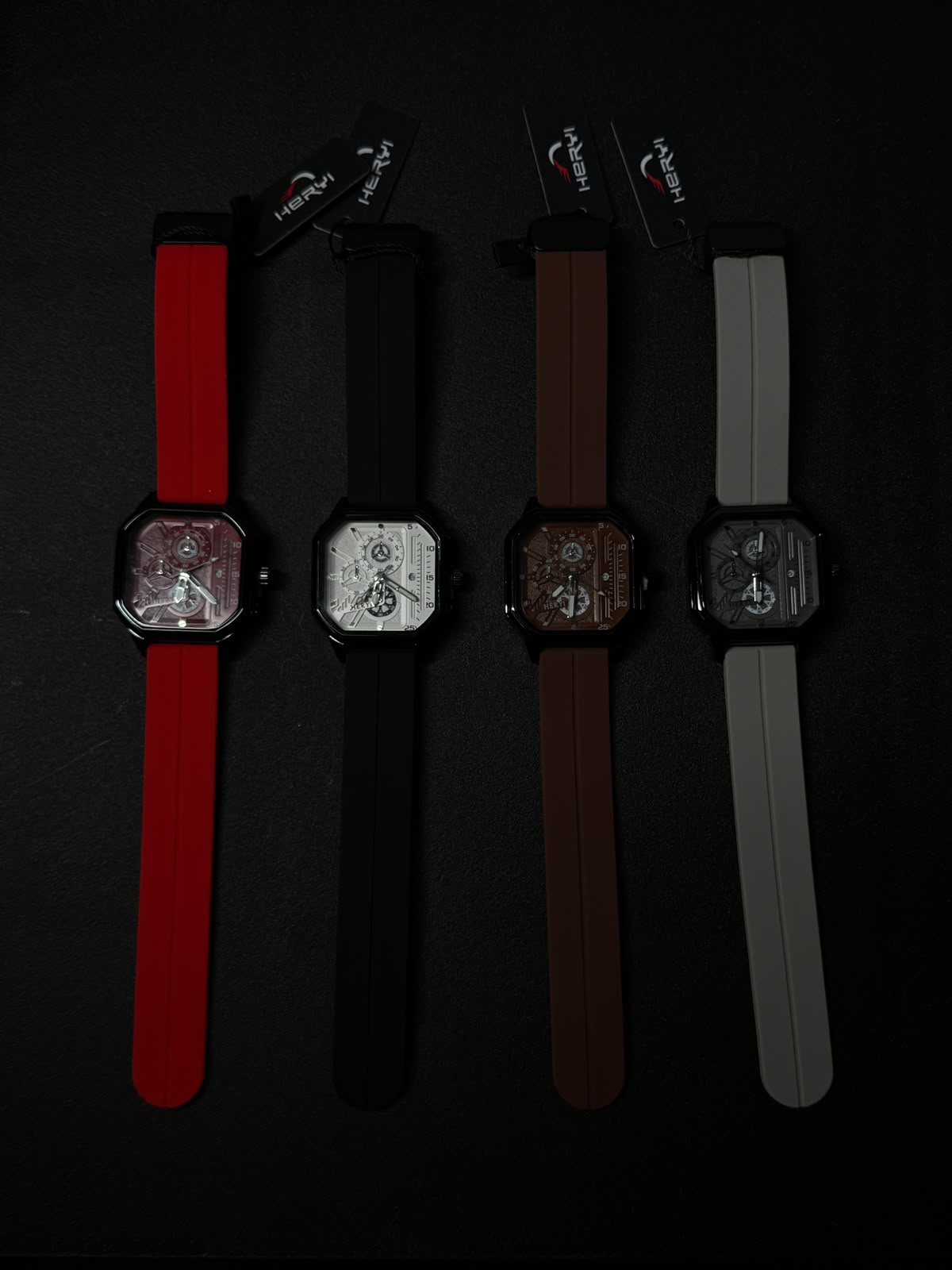 Premium replica watch collection featuring square skeleton dial design with red, black, brown, and grey silicone straps on black background.
