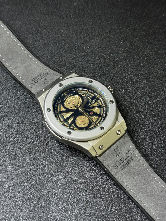 Premium replica watch featuring open skeleton dial, grey case, leather strap, luxury inspired men's wristwatch angled product view
