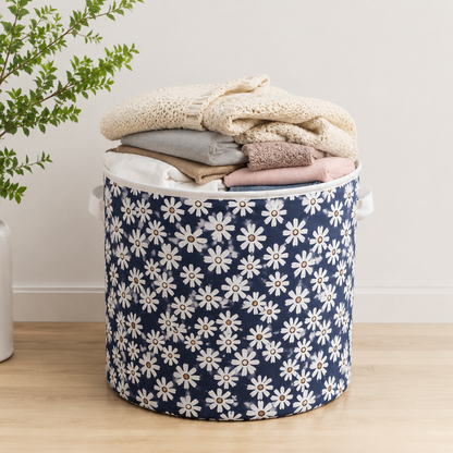 Round floral fabric laundry basket filled with folded clothes, featuring a stylish blue daisy pattern for home storage and organisation.
