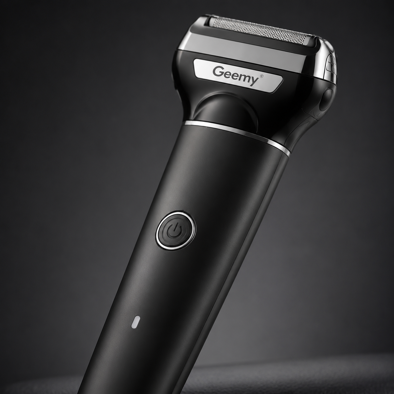 Close-up of a rechargeable electric foil shaver featuring a stainless steel shaving head, ergonomic matte black handle and one-touch power button