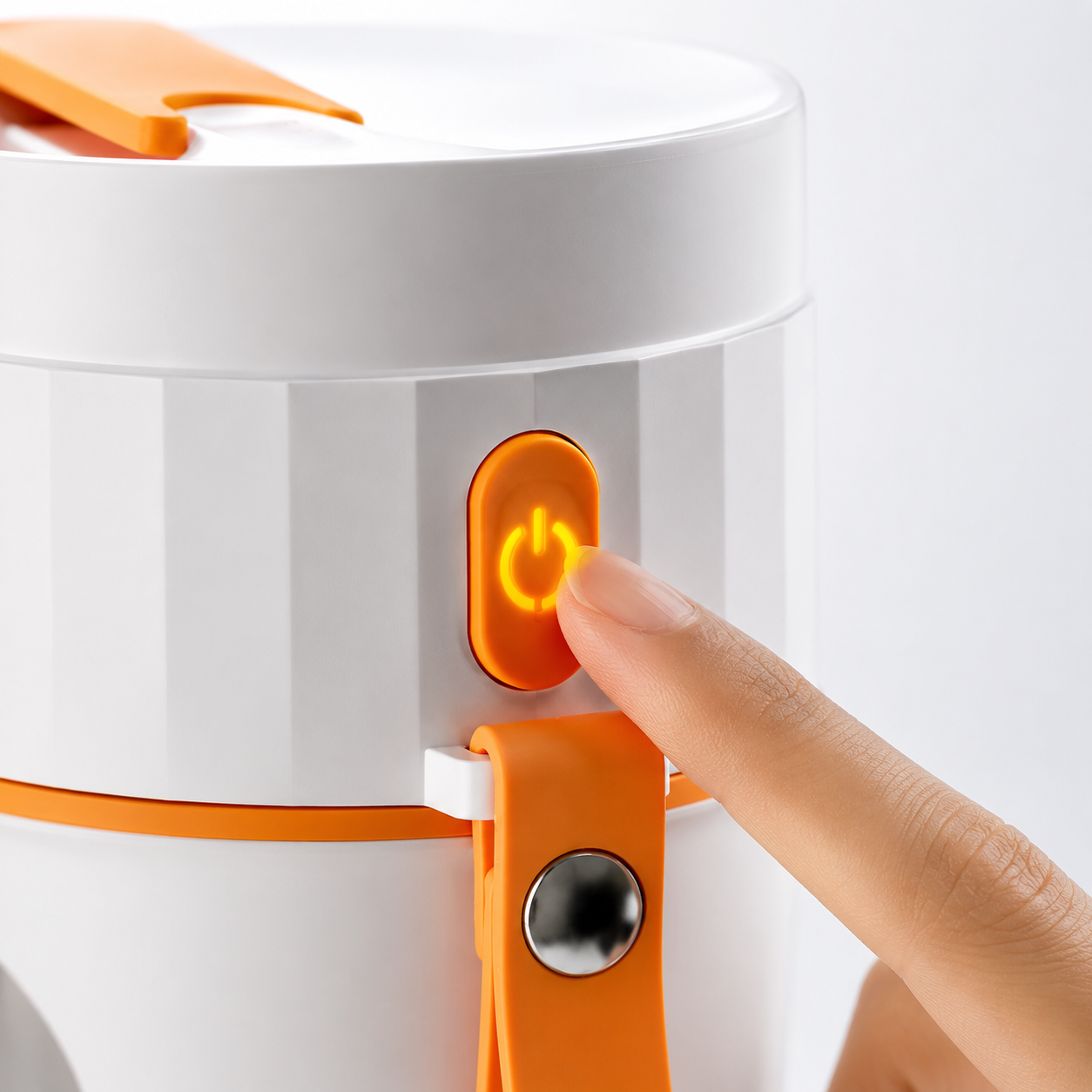 Close-up of a finger pressing the illuminated one-touch power button on the HP-890 portable USB rechargeable juicer blender with integrated carry strap.