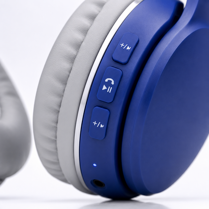 Close-up of wireless headphone earcup showing integrated playback, call and volume control buttons with soft padded ear cushions and LED indicator.