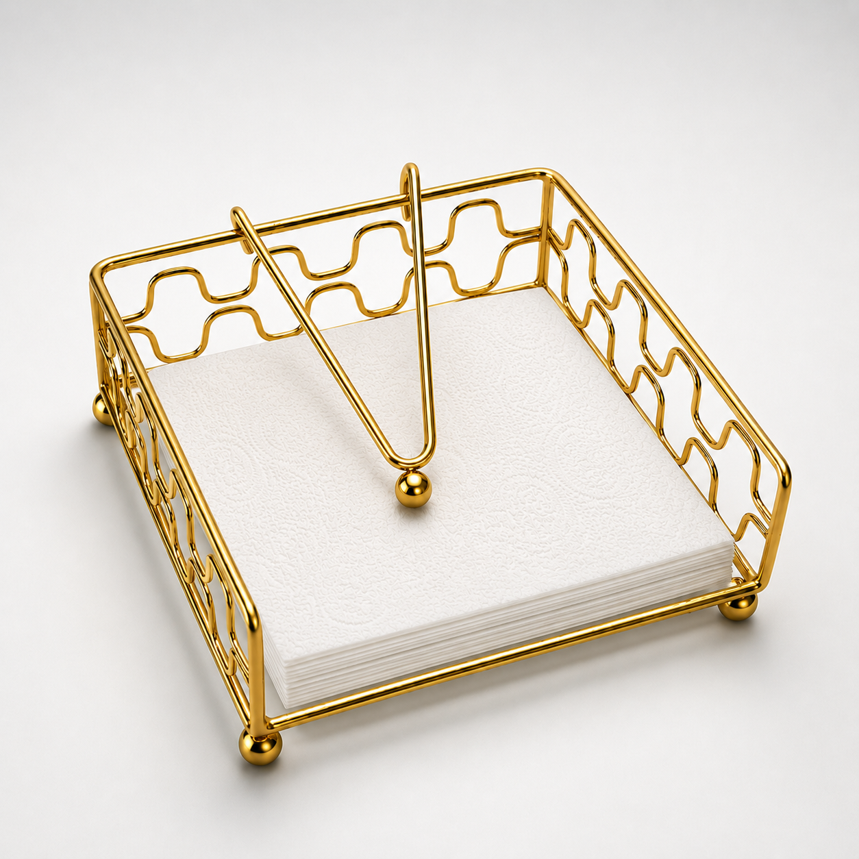 Aurea Gold Metal Tissue Holder holding white paper napkins, elegant tabletop napkin organizer with weighted arm and gold finish