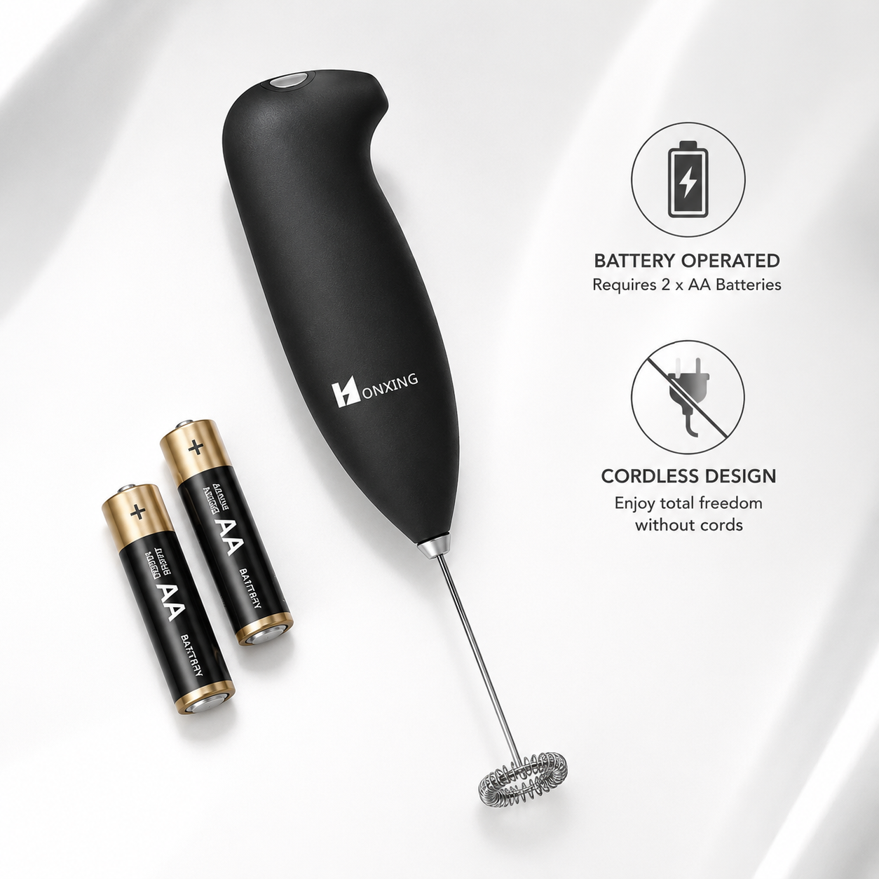Battery-operated handheld milk frother with ergonomic soft-touch black handle and stainless steel whisk displayed beside two AA batteries, highlighting cordless operation and portable coffee frothing convenience.