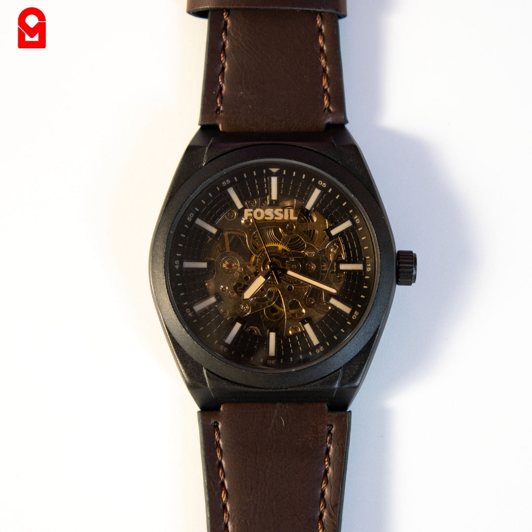 Close-up of black skeleton dial automatic watch displaying internal movement.