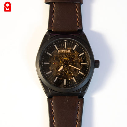 Close-up of black skeleton dial automatic watch displaying internal movement.