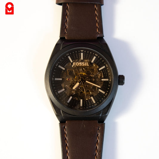 Close-up of black skeleton dial automatic watch displaying internal movement.