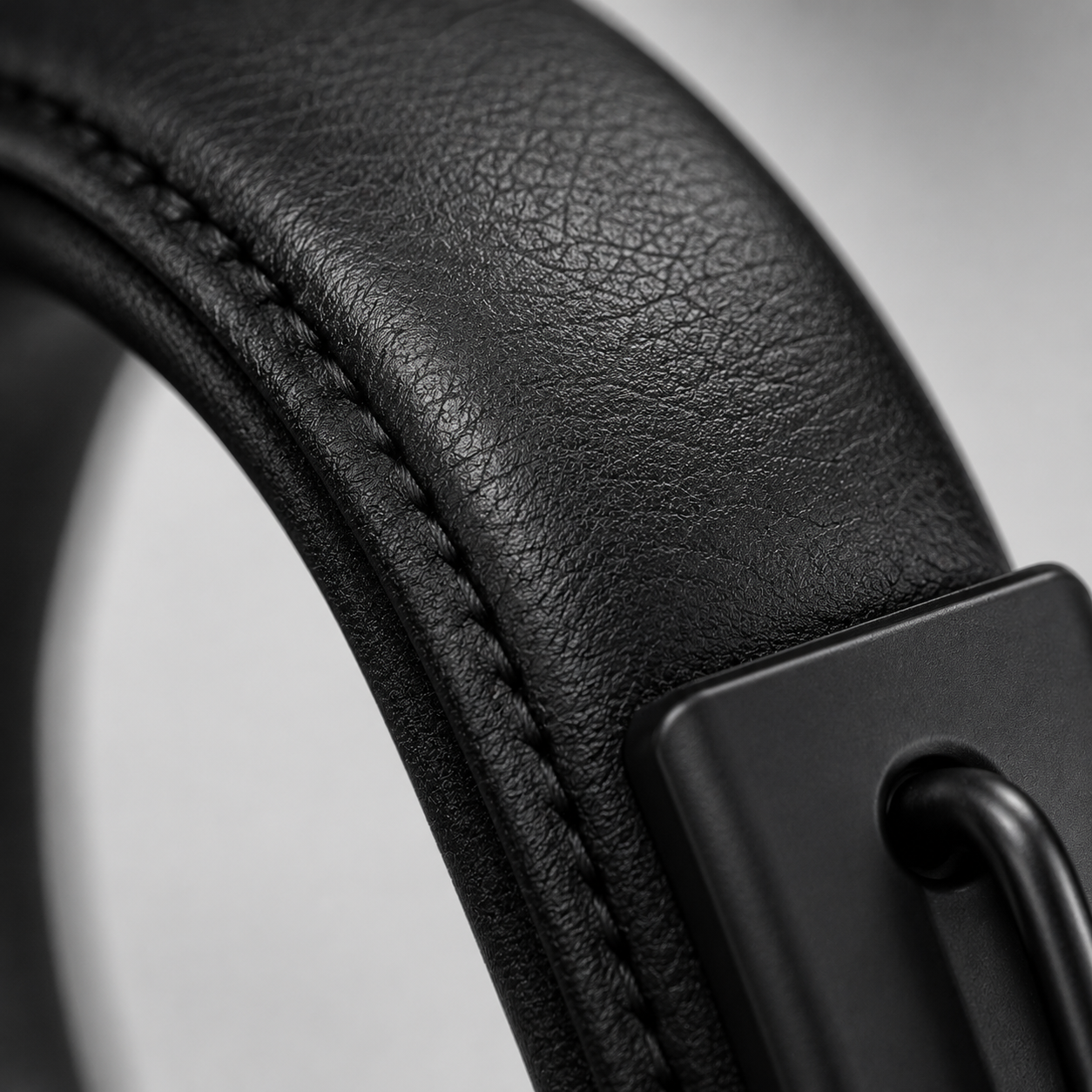 Close-up macro view of the premium padded headphone headband showcasing the soft leather-textured cushion, reinforced stitching, and durable ergonomic construction for long-lasting wearing comfort.