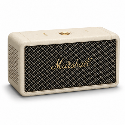 Cream retro portable Bluetooth speaker featuring a textured leather-look finish, black metal grille, gold logo badge and minimalist top controls
