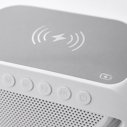Close-up of the LED wireless charging Bluetooth speaker showing the soft-touch wireless charging pad with Qi charging symbol, integrated control buttons, and premium white finish.