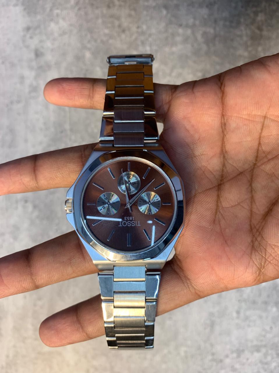 Brown Dial Steel Chronograph Watch with stainless steel bracelet and octagonal case on wrist.