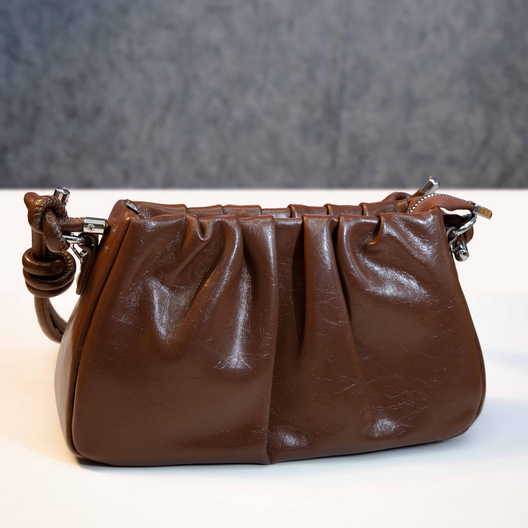 Brown ruched shoulder bag with compact structured back design.