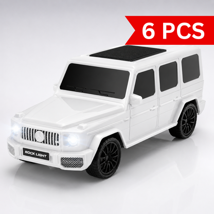 Glossy white SUV-inspired portable Bluetooth speaker with illuminated LED headlights and roof-mounted speaker grille on a premium studio background