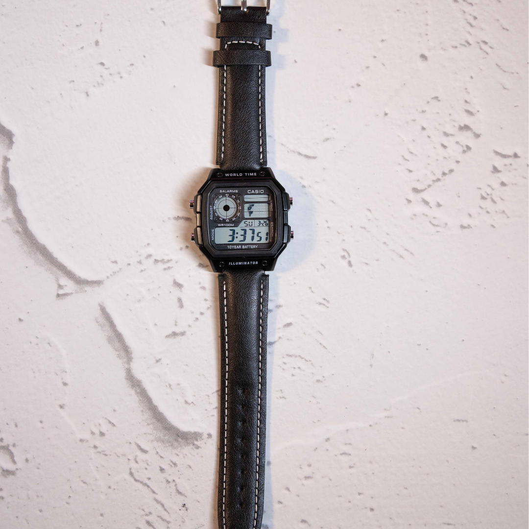 Classic Black Digital Square Watch with retro digital display and black leather strap on marble background