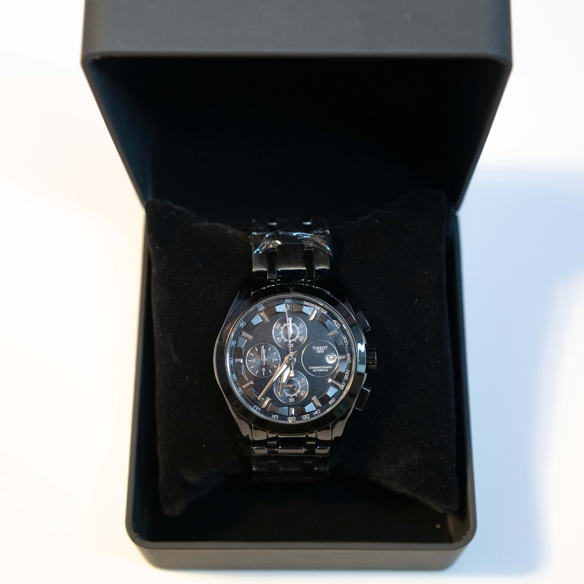 Premium black stainless steel chronograph watch displayed in luxury watch box