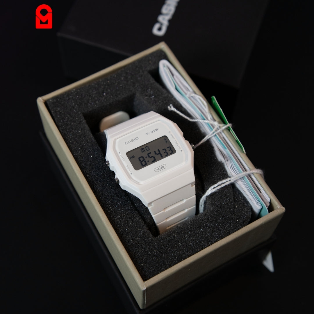 White digital wrist watch with LCD display and resin strap in packaging.