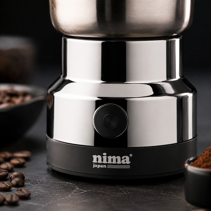 Close-up of a compact electric grinder featuring a one-touch power button, polished metal body and modern countertop design.