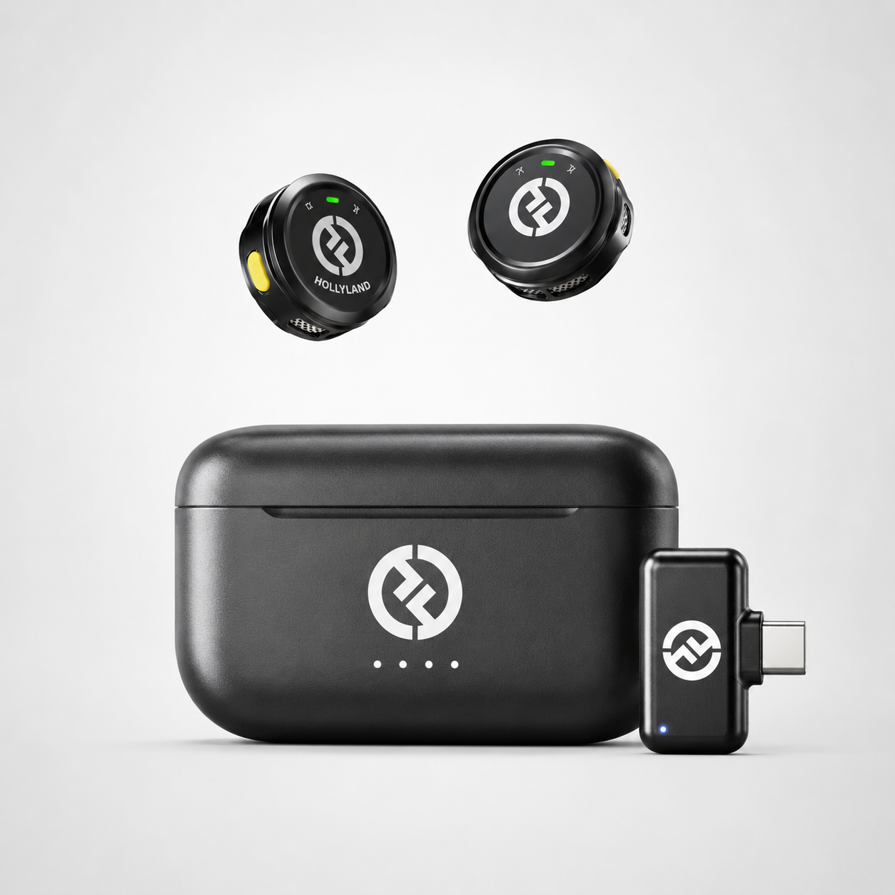Compact wireless lavalier microphone system featuring two button-sized transmitters, USB-C receiver adapter, and portable charging case displayed on a clean white background.
