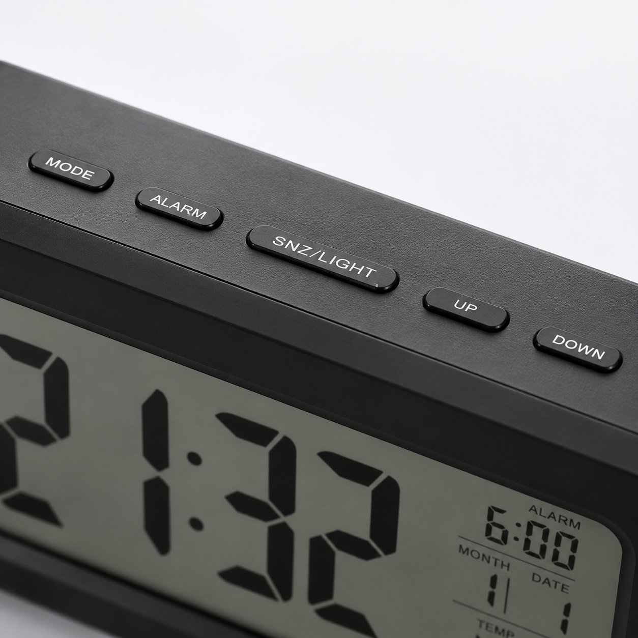 Close-up of the digital alarm clock's top control panel featuring Mode, Alarm, Snooze/Light, Up and Down buttons with a large LCD display showing time, alarm, calendar and temperature.