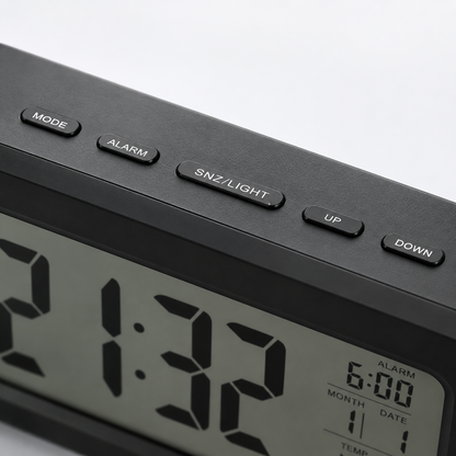 Close-up of the digital alarm clock's top control panel featuring Mode, Alarm, Snooze/Light, Up and Down buttons with a large LCD display showing time, alarm, calendar and temperature.