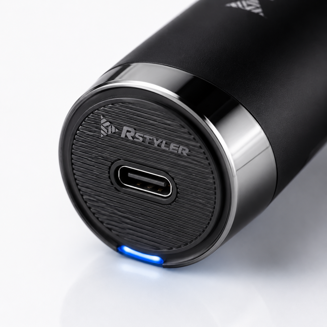 Close-up macro image of a professional hair trimmer with USB Type-C charging port, textured base, LED charging light, and premium cordless grooming design.