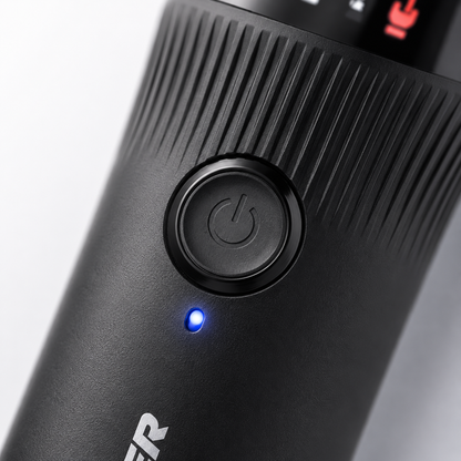 Macro close-up of a cordless hair trimmer featuring an ergonomic power button, textured anti-slip grip, LED indicator light, and modern matte black finish.