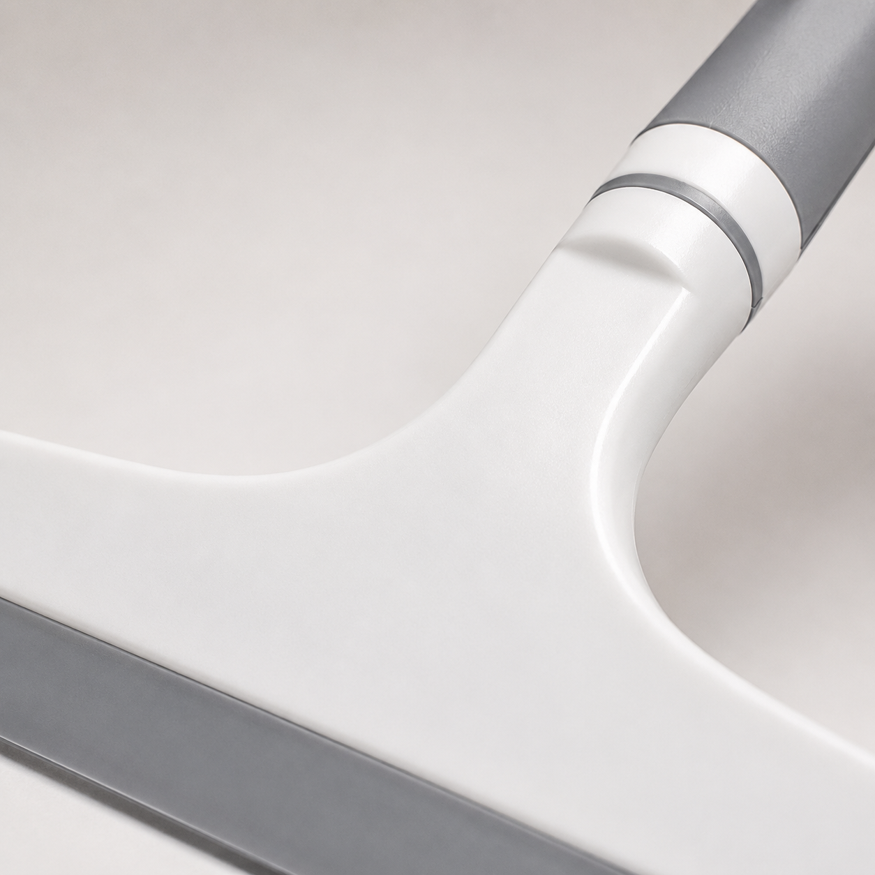Close-up of ergonomic grey non-slip handle and durable body construction on silicone glass cleaning wiper