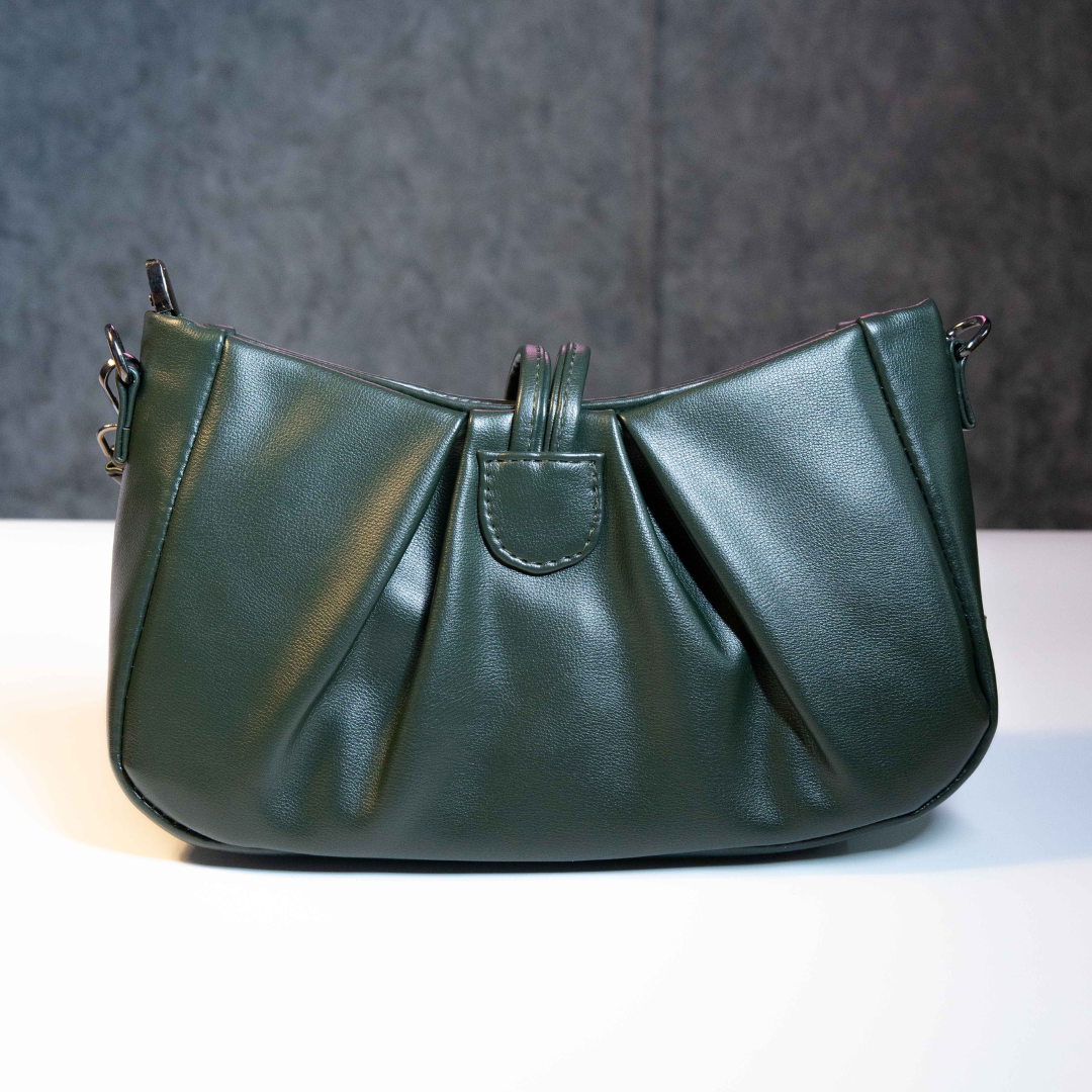 Emerald green shoulder bag with ruched back and structured shape.