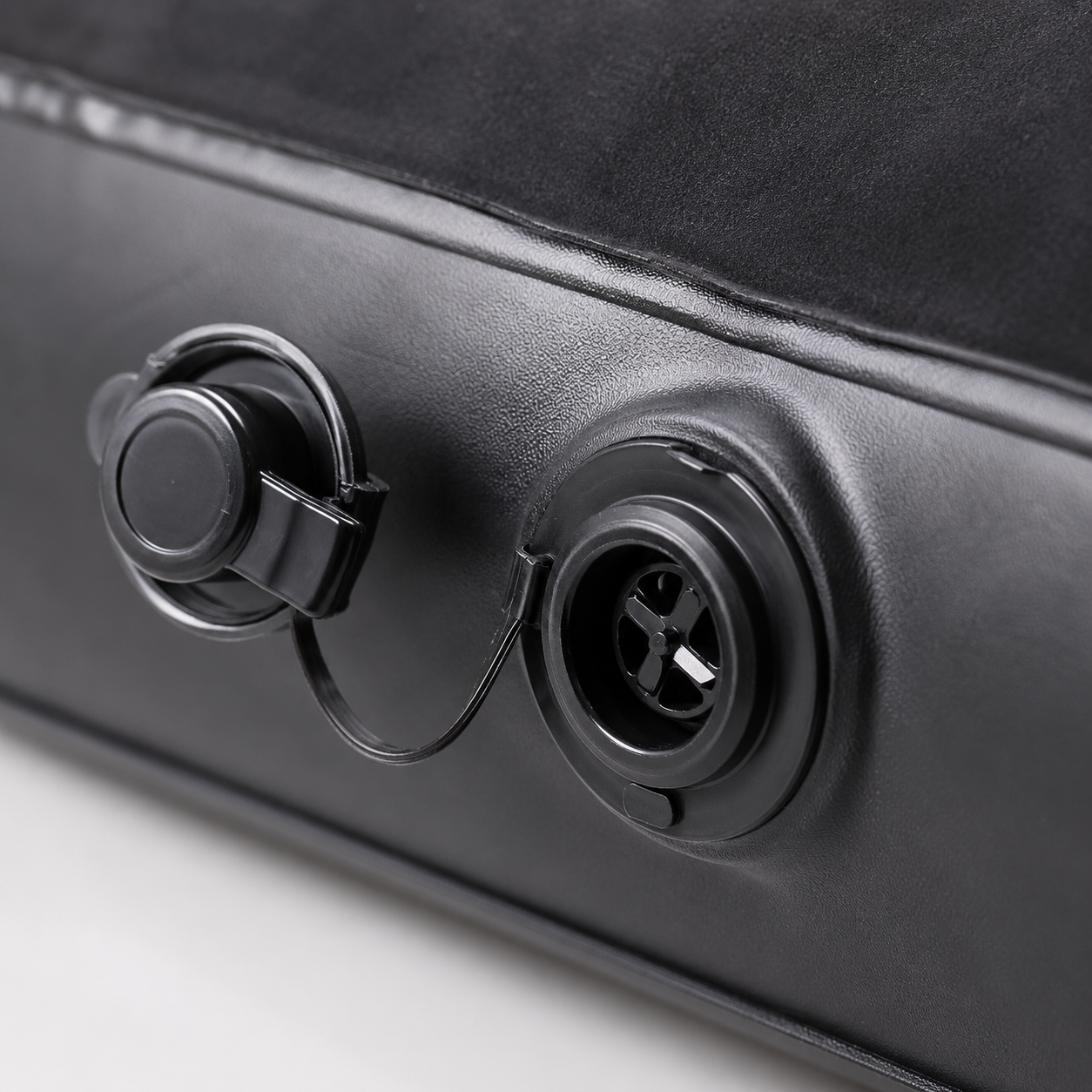 Close-up view of the air valve system on an inflatable car mattress, showing the inflation and deflation port.