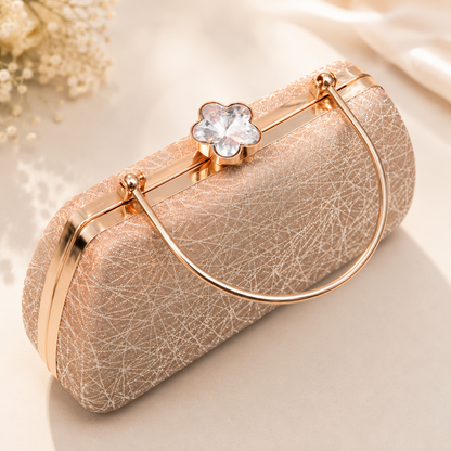 Rose gold glitter evening clutch bag with crystal flower clasp and metal handle, luxury women's party purse displayed on a soft beige background.
