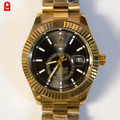 Close-up of gold tone automatic wrist watch with black dial and metal bracelet.
