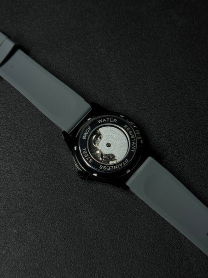 Skeleton replica watch with exhibition case back, visible mechanical movement, grey silicone strap and black stainless steel case