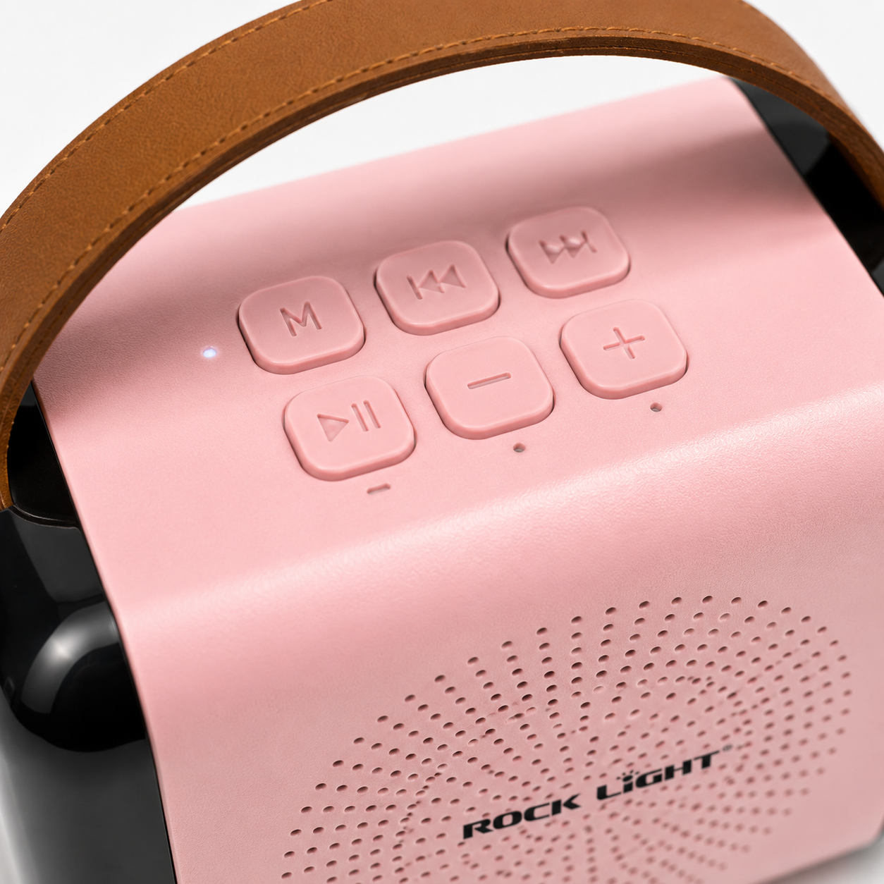 Close-up of the portable karaoke speaker showing top-mounted media controls, volume buttons, mode button, LED indicator, and premium carry handle with soft pink finish.