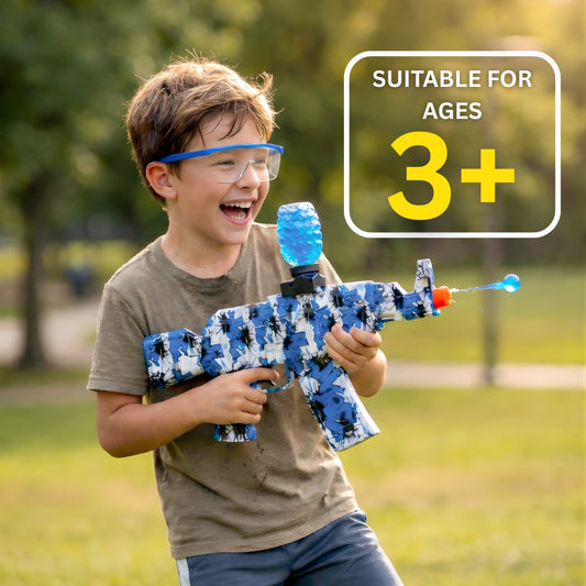 Child holding Kids Electric Gel Blaster Gun Kit with Safety Glasses outdoors, smiling with a vibrant blue gel bead in motion, with text 'SUITABLE FOR AGES 3+'.