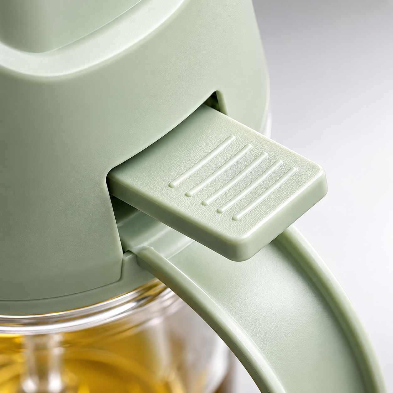 Macro close-up of Kitchen Oil Sprayer & Dispenser ergonomic press button featuring textured anti-slip surface for comfortable and precise oil spraying control.
