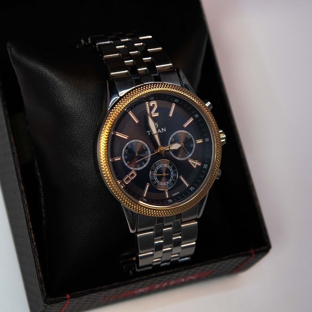 Close-up of men’s analog chronograph watch with black dial and stainless steel bracelet.