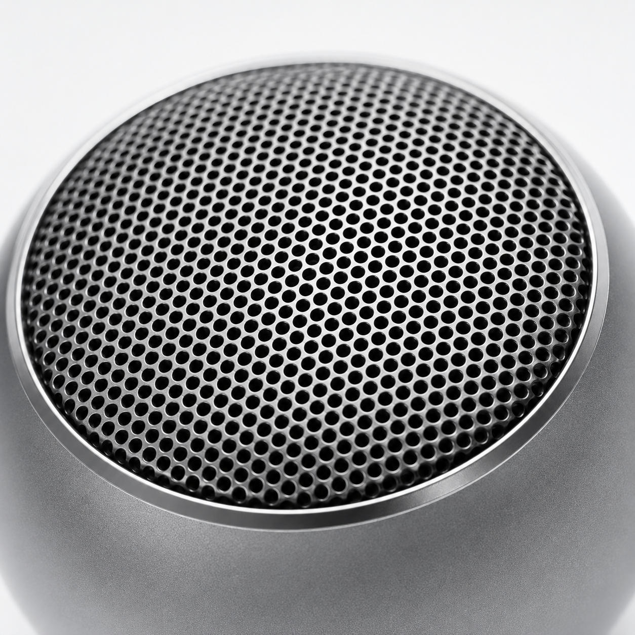 Extreme close-up of the precision perforated metal speaker grille, showcasing the premium aluminium alloy construction and high-quality acoustic mesh of the portable Bluetooth speaker.
