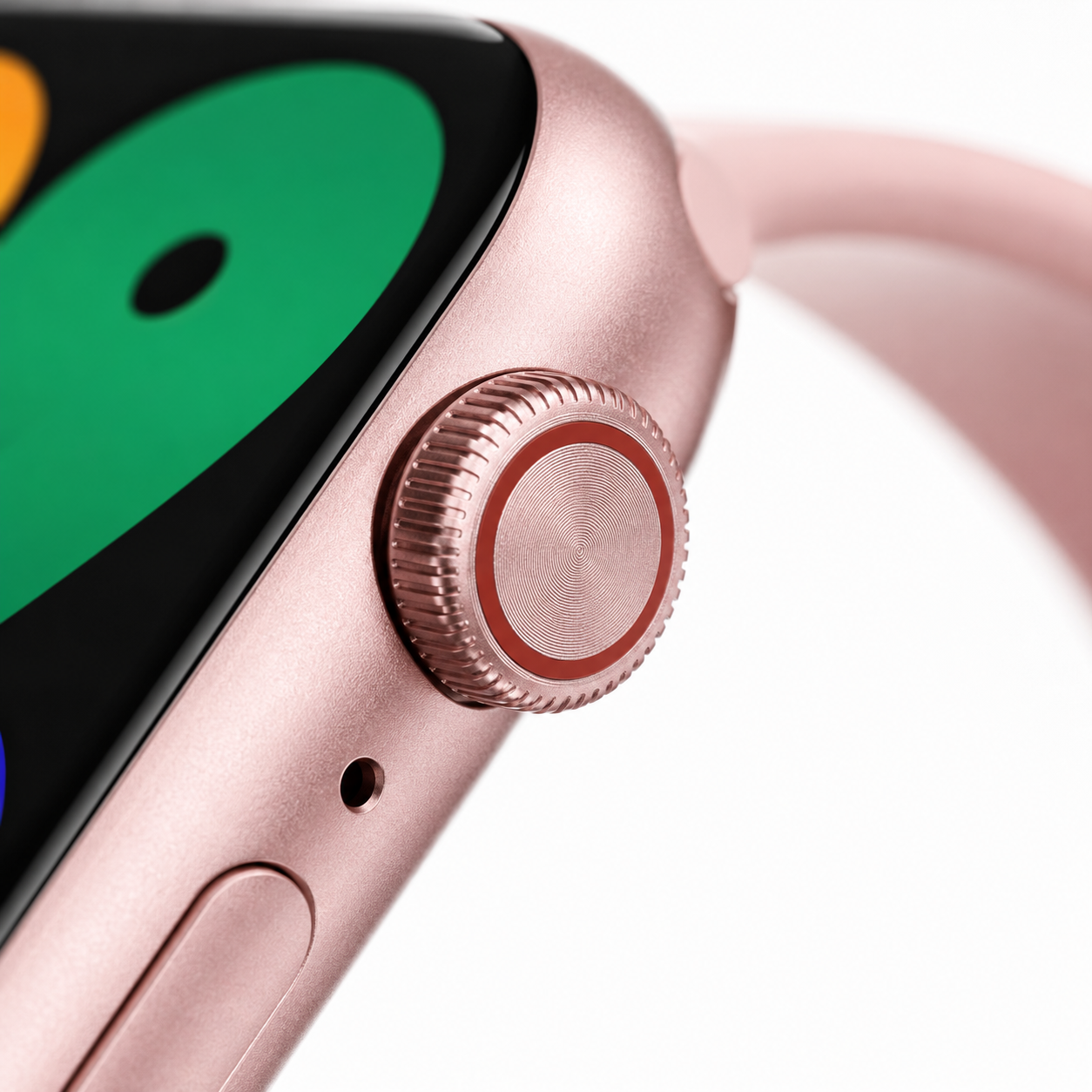 Extreme macro close-up of the smartwatch's precision digital crown, side button and premium pink metallic case with a smooth matte finish and curved display edge.