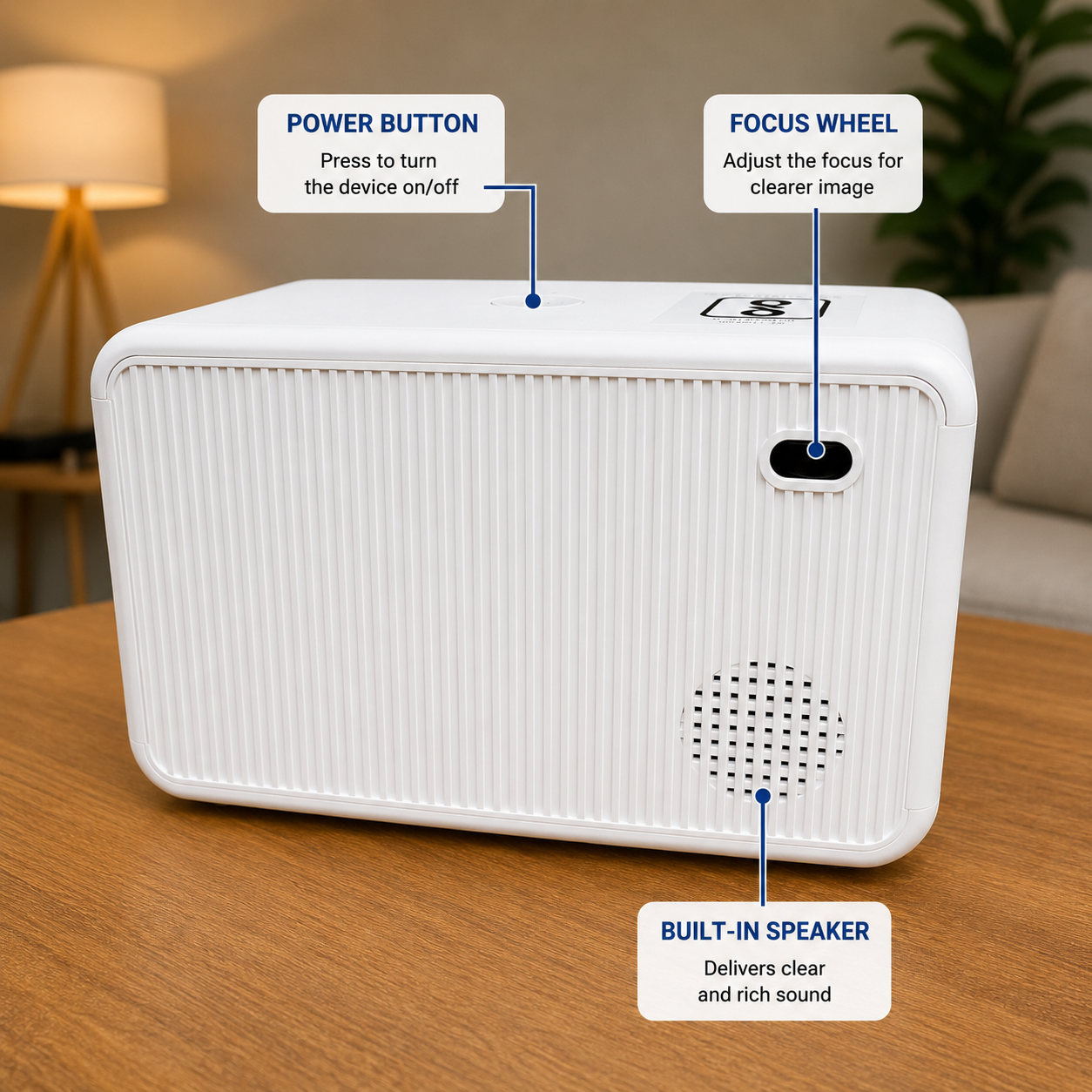 Rear view of a compact portable LED projector highlighting the top power button, manual focus wheel, and built-in speaker. Modern white projector designed for easy home cinema setup.