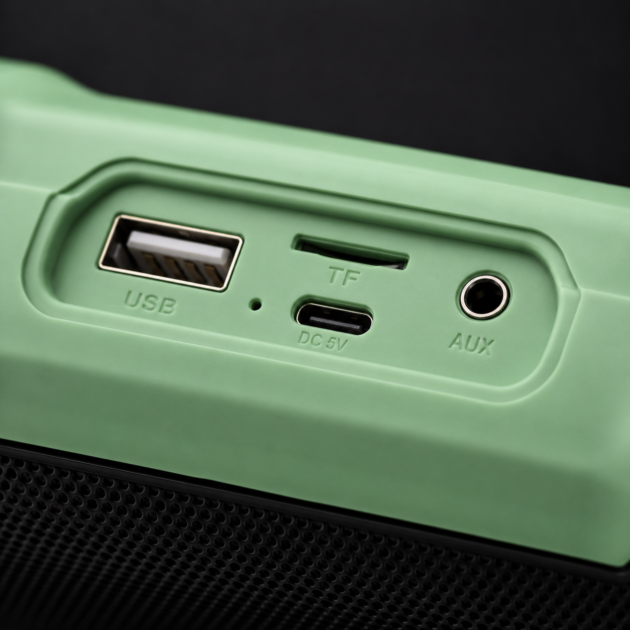 Close-up view of Rock Light Magic S156 speaker connectivity ports including USB port, TF card slot, USB charging input, and 3.5mm AUX audio input on a green speaker housing.