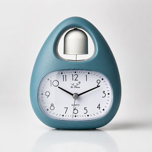 Teal blue single bell alarm clock with quartz accuracy, large analog face, battery-powered operation, and decorative desk clock design.
