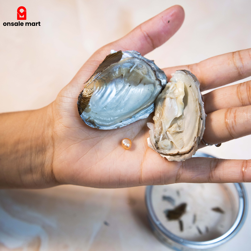Hand holding an opened oyster shell with a pearl inside from the Pearl Gift Set.