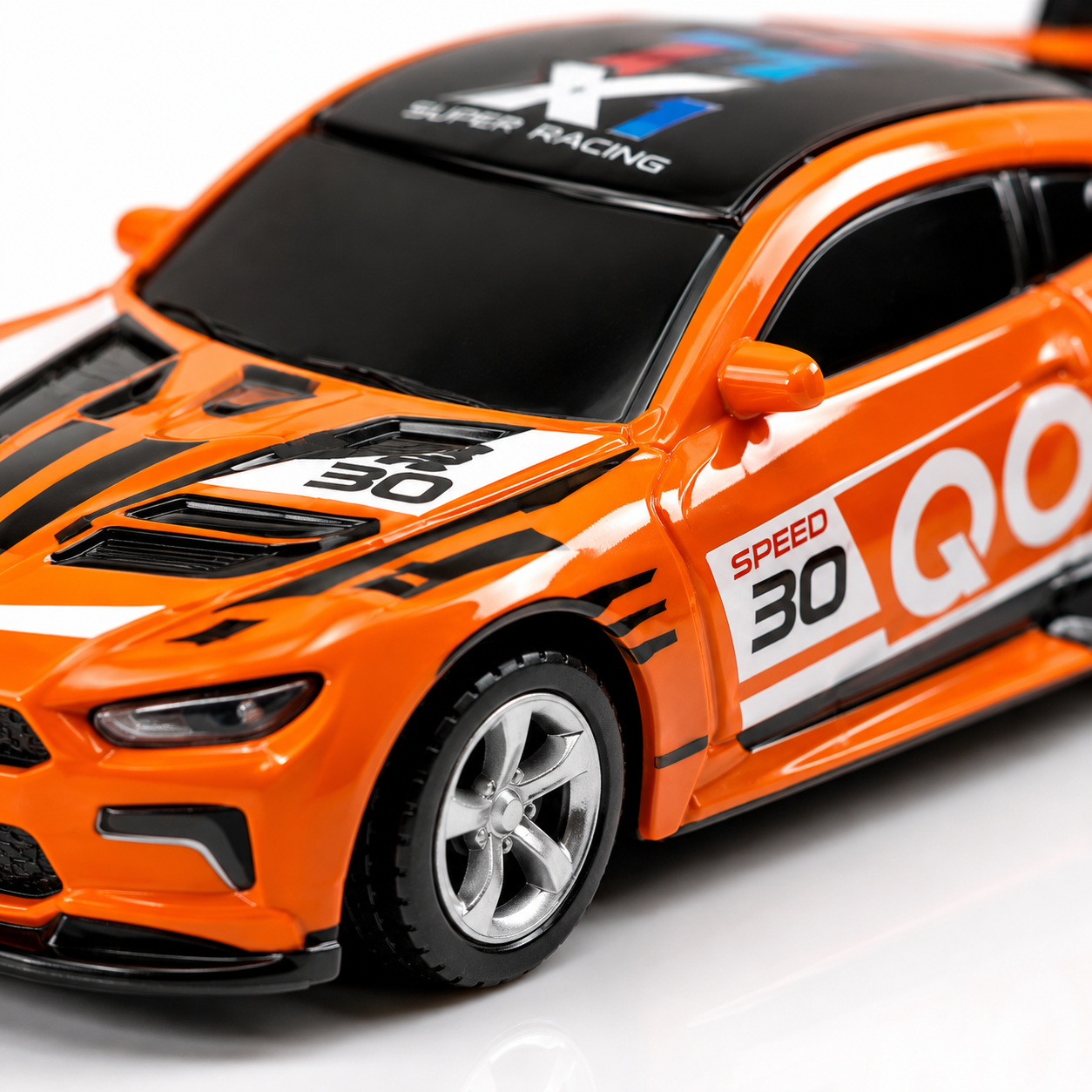 Close-up of an orange 1:64 alloy remote control racing car featuring detailed body graphics, aerodynamic styling, sporty wheels, and realistic racing decals.