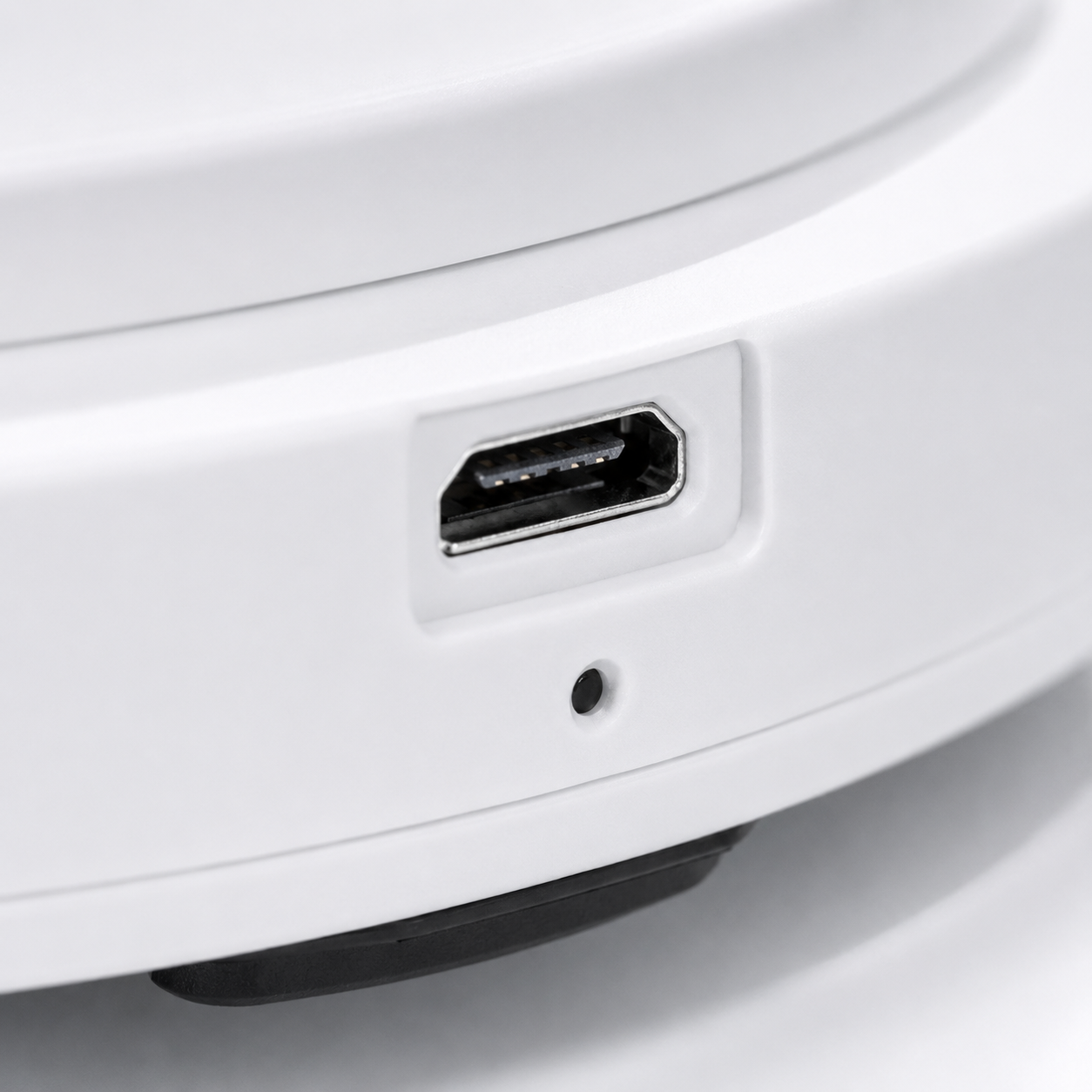 Macro view of the robot vacuum cleaner's USB charging port with LED indicator, showcasing the rechargeable design on a clean white housing.