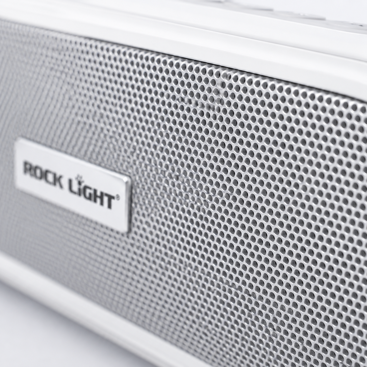 Detailed macro view of the perforated metal speaker grille on a 20W wireless soundbar with premium silver finish and Rock Light branding.